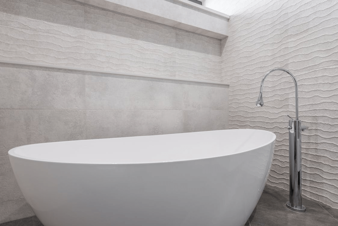 A free-standing tub in the bathroom corner 