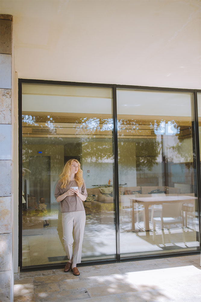 A woman standing in front of a glass door