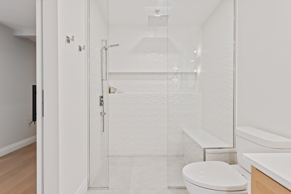 A curbless shower area with a bench and frameless glass doors