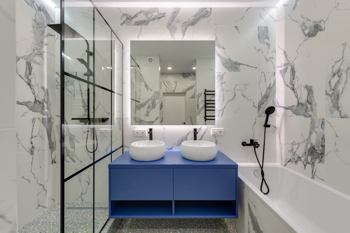 a modern bathroom with a tub, vanity, and custom shower enclosure