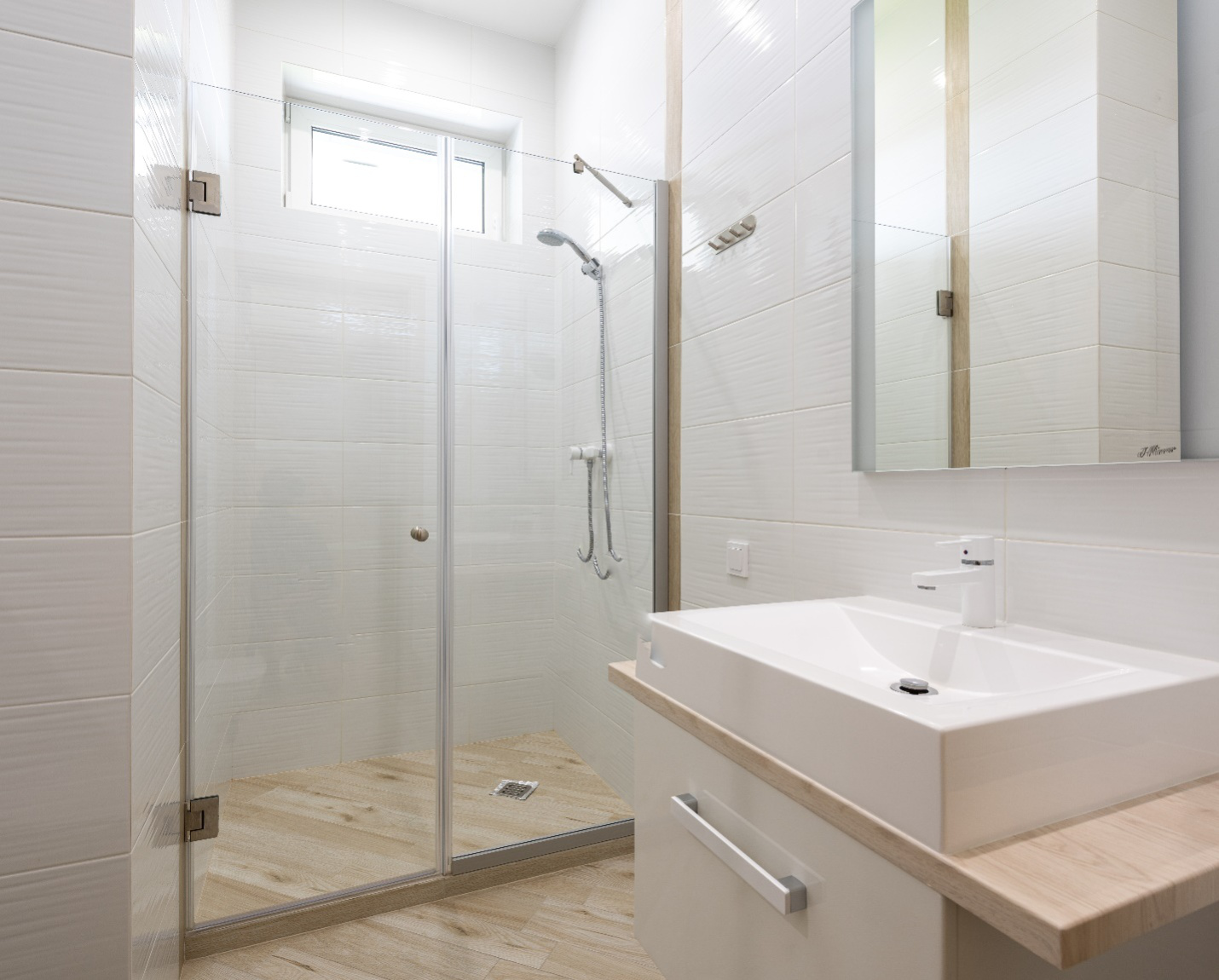 a modern bathroom with large frameless shower glass doors and a sink and mirror